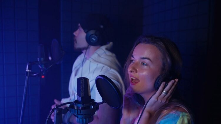 Musicians recording vocals in a professional studio for a music contract deal