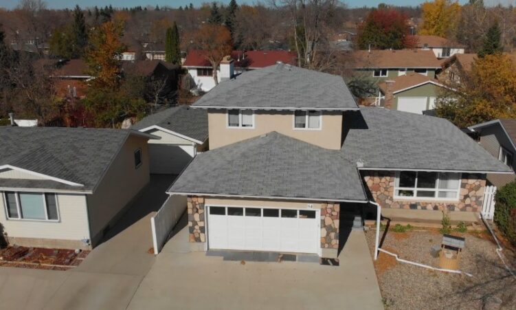 Aerial view of a residential home featuring two garages adjacent to the property