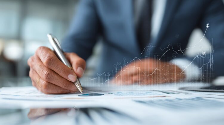Business professional reviewing financial charts and signing documents