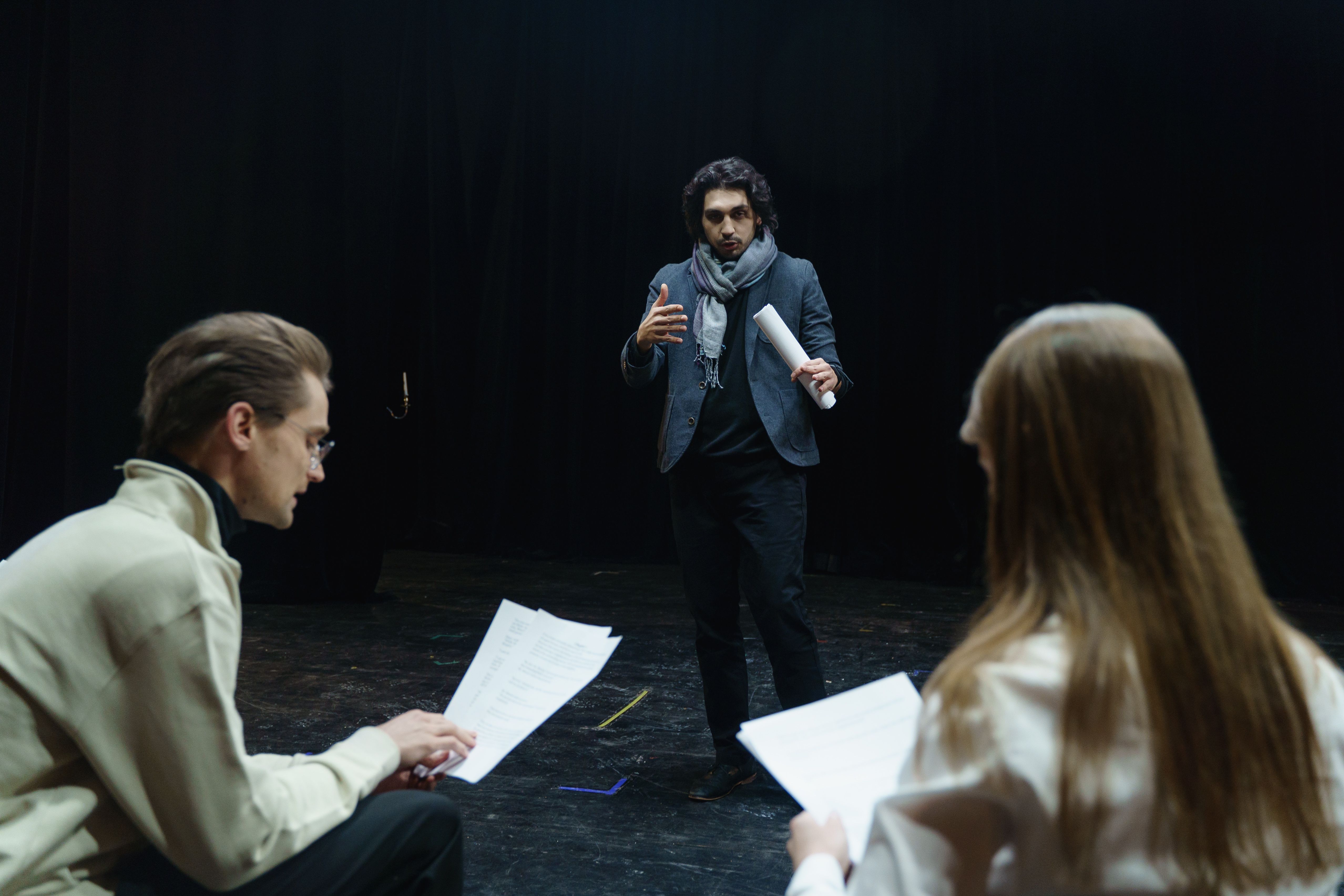 Casting director observes actors rehearsing together, assessing their collaboration and performance.